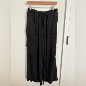 Black baggy cargo pants with drawstring waist and large pockets. Reformation